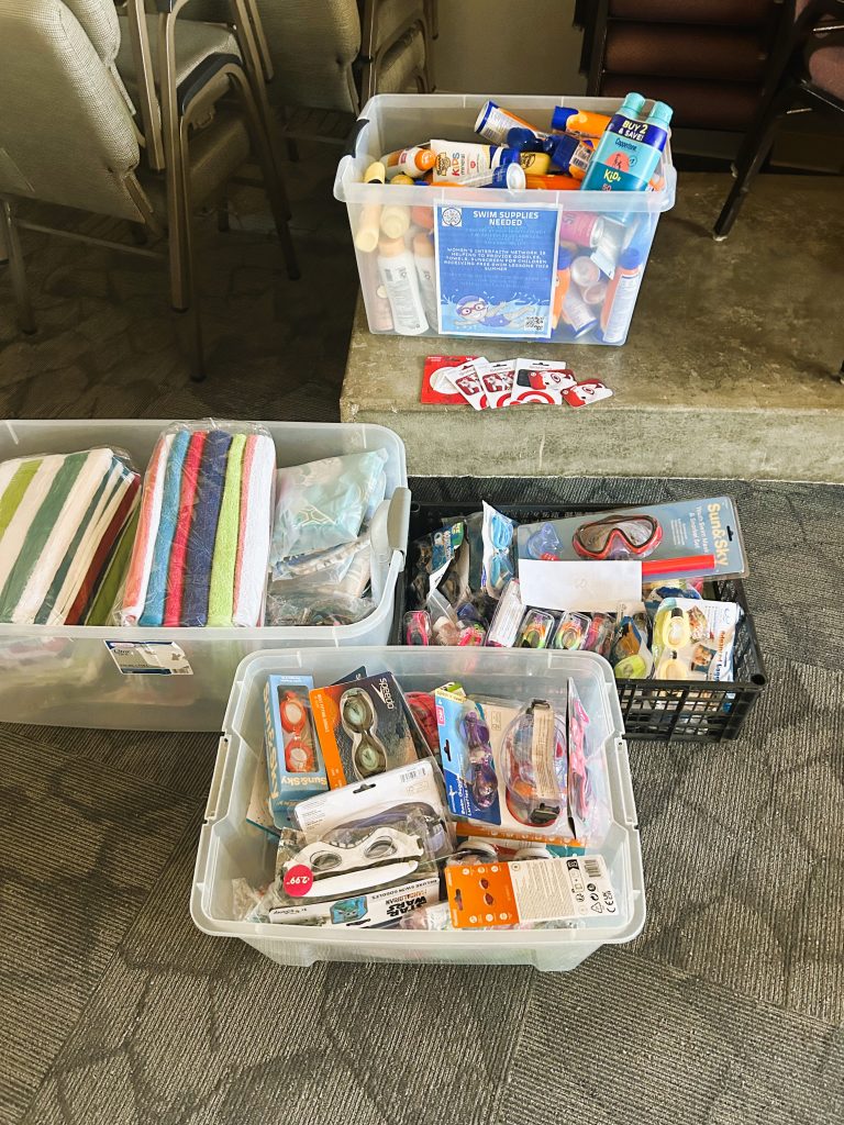 Picture of goggles, towels and other swim supplies in bins
